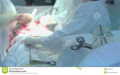 Doctors In Hospital Wearing Protective Clothing Performing Surgery