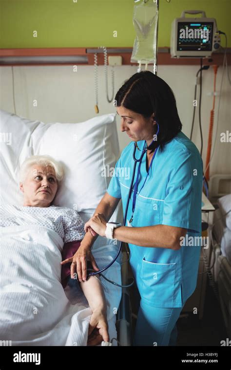 Nurse Checking Blood Pressure Of Senior Patient Stock Photo Alamy
