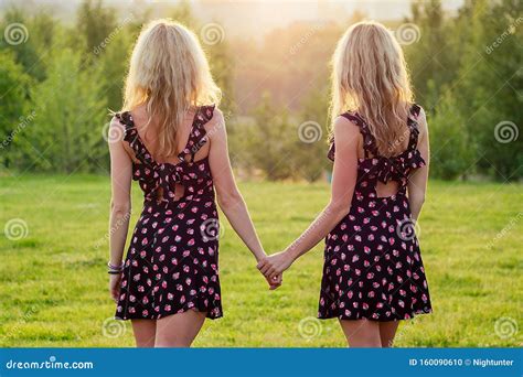 Deux Lesbiennes Soeurs Jumelles Belle Jeune Femme Bouclée En Robe élégante Se Tenant La Main Au