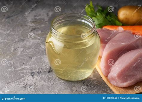 Fresh Poultry Broth In A Glass Jar On A Table With Vegetables And