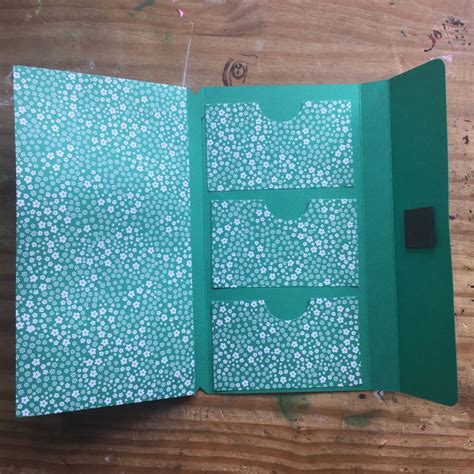 An Open Green Book With White Flowers On It