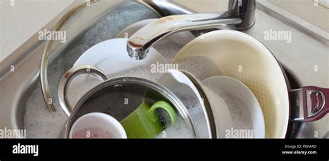 Dirty Dishes And Unwashed Kitchen Appliances Filled The Kitchen Sink
