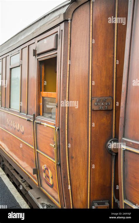 Close Up Vintage Teak Uk Railway Carriage Alongside Platform At