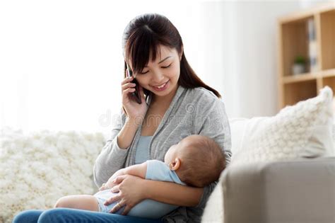 Mother With Baby Calling On Smartphone At Home Stock Image Image Of