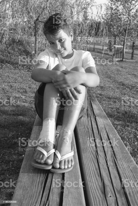 Portrait Of Cute Teenage Boy Sitting On A Bench Stock Photo Download