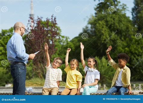 Group Of Kids Raising Hands In Outdoor Lesson Stock Photo Image Of