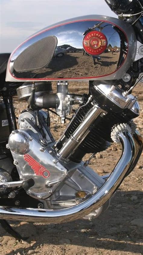 The Front End Of A Motorcycle Parked On Top Of A Dirt Field Next To A