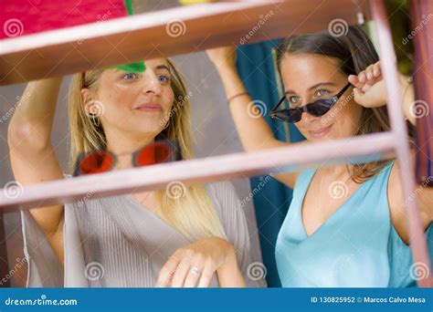 Lifestyle Natural Portrait Of Young Beautiful And Happy Girlfriends Trying On Sunglasses