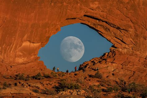 Surreal Moon Photo Looks Like A Giant Eye Peeking Through Rock Arch In