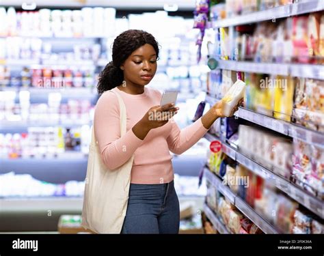 Serious Black Woman With Eco Tote Bag Buying Groceries At Supermarket