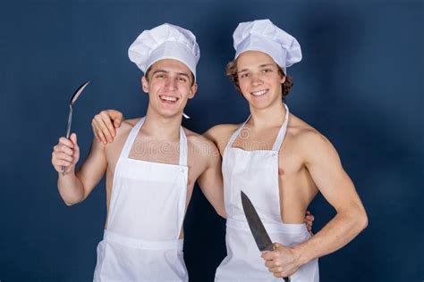 Two Handsome Chefs With Apron On Naked Muscular Body With Kitchen