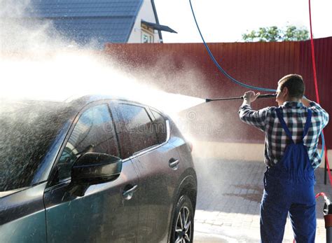 Worker Cleaning Automobile With High Pressure Water Jet Stock Image
