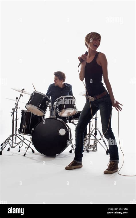 A Female Singer And A Man On Drums Performing Studio Shot White