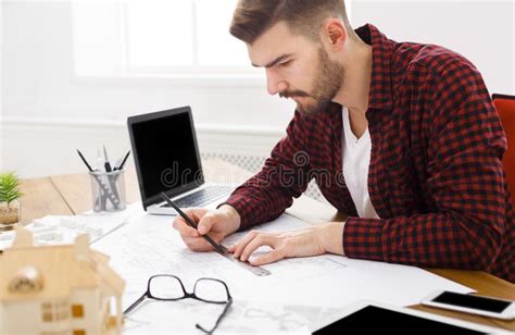Young Architect Working With Blueprints In The Office Stock Image