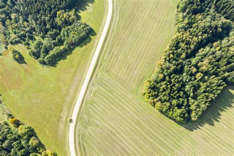 Dirt Road Crossing Through Cultivated Fields And Forests Aerial View