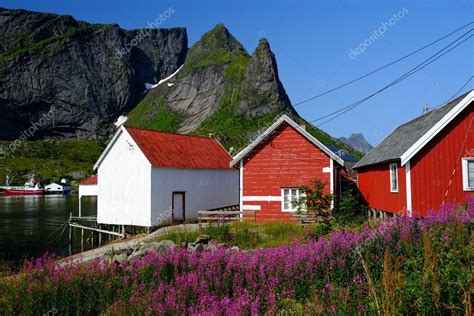 Traditional Wooden Houses Against Mountain Peak In Reine Village