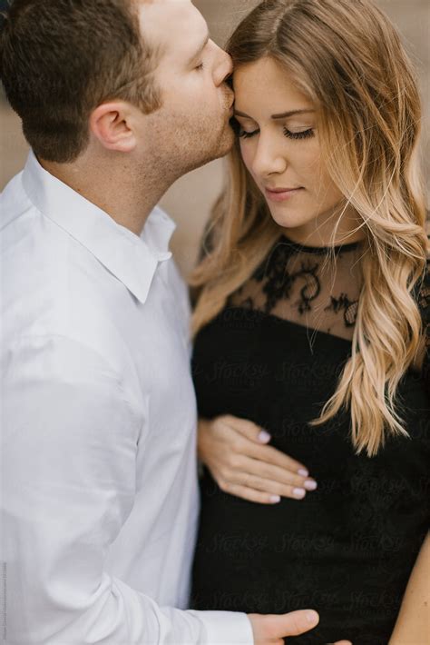 Husband Kissing His Pregnant Wife On The Forehead By Stocksy Contributor Kristen Curette