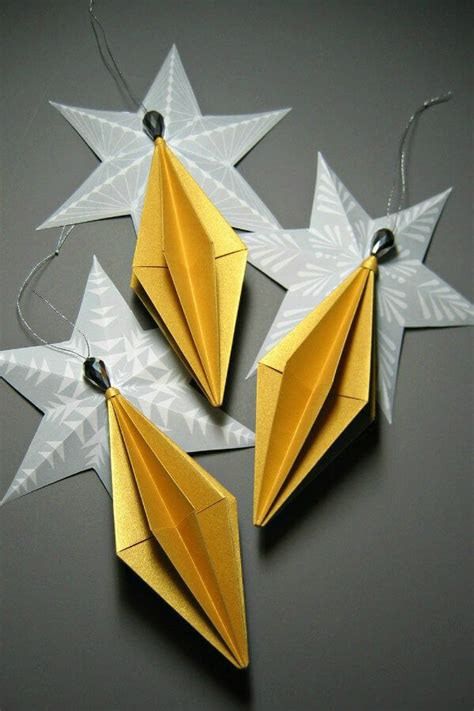 Metallic Paper Diamond Origami Ornaments Resting On Folded Paper Stars
