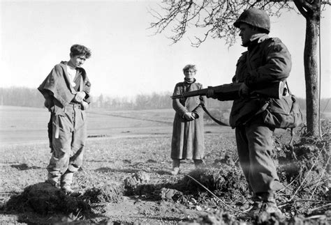 Two German Pows Are Guarded By A Us Army Soldier Of The 44th Infantry