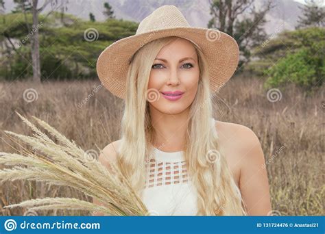 Portrait Beautiful Young Blonde In A Hat Posing On The Prairie In The