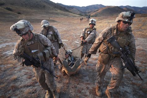 Marines carry a simulated casualty after performing a live-fire defense ...