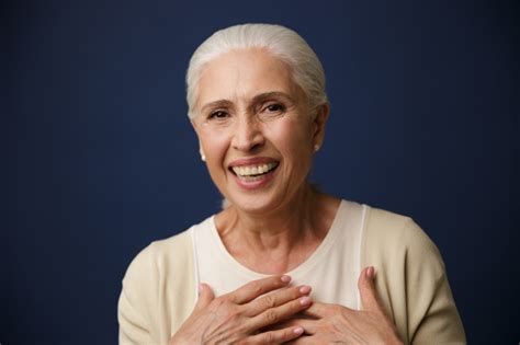 Close Up Portrait Of Laughing Mature Woman Holding Hands On Her Chest