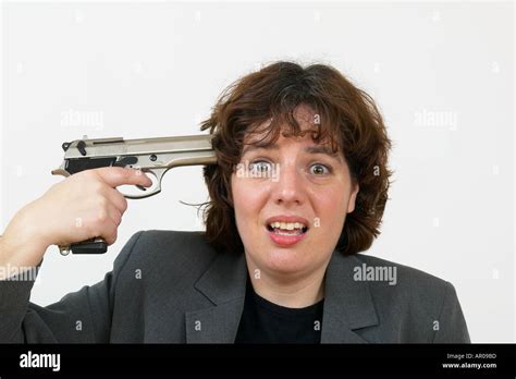 Woman In Suit With A Gun Pointing Gun At Her Head Stock Photo Alamy