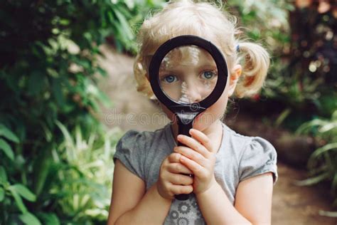 Caucasian Girl Looking In Camera Through Flowers Through Magnifying Glass Stock Image Image Of