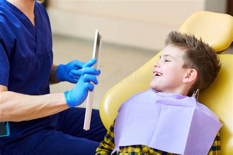 O Dentista Verifica Os Dentes De Um Adolescente Do Menino Do Homem Foto