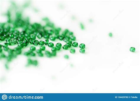 Green Color Seed Beads Scattered On Textile Background Stock Photo