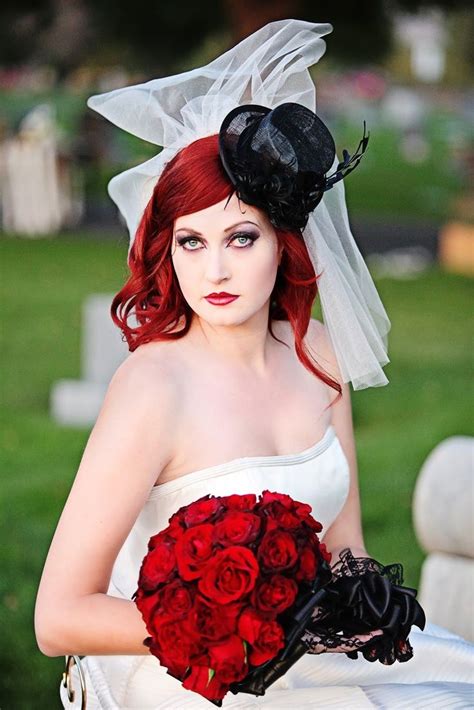 A Woman With Red Hair Wearing A White Dress And Black Hat Holding A