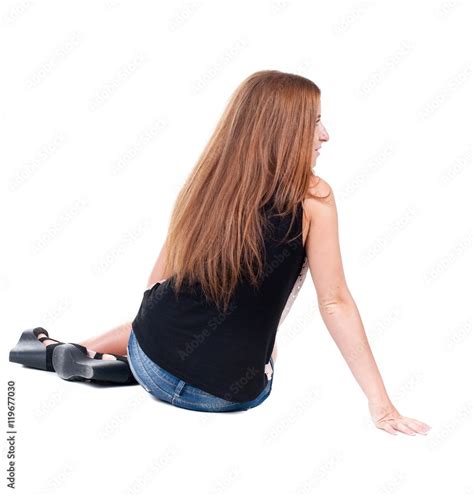 Back View Beautiful Young Woman Sitting On Floor And Looks Into