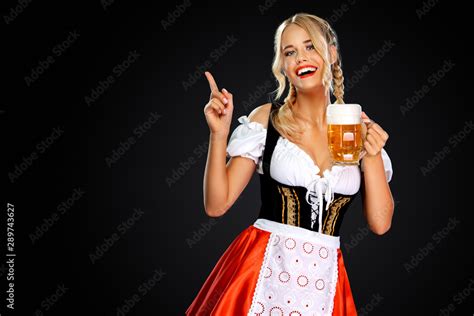 Smiling Sexy Oktoberfest Girl Waitress Wearing A Traditional Bavarian Or German Dirndl Serving