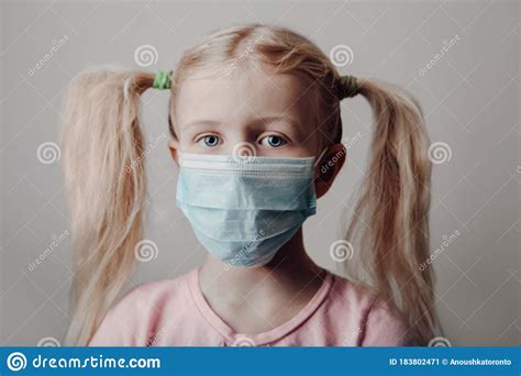 Portrait Of Caucasian Blonde Girl In Sanitary Face Mask Preschool