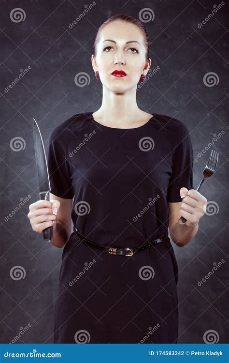 Portrait Of A Beautiful Young Woman With A Knife And A Fork In Her