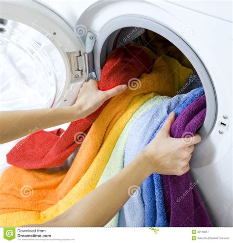 It's not uncommon for colored clothes to fade in the washer. Woman Taking Clothes From Washing Machine Royalty Free ...