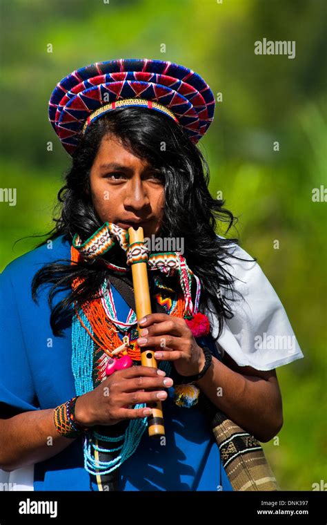 a native from the kamentsá tribe wearing a colorful headgear plays flute during the carnival