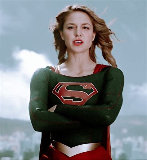 A Woman Dressed As A Supergirl With Her Arms Crossed