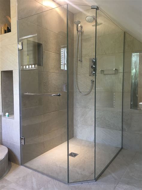 frameless pentagonal shower enclosure installed in loft and shaped to sloping ceiling in