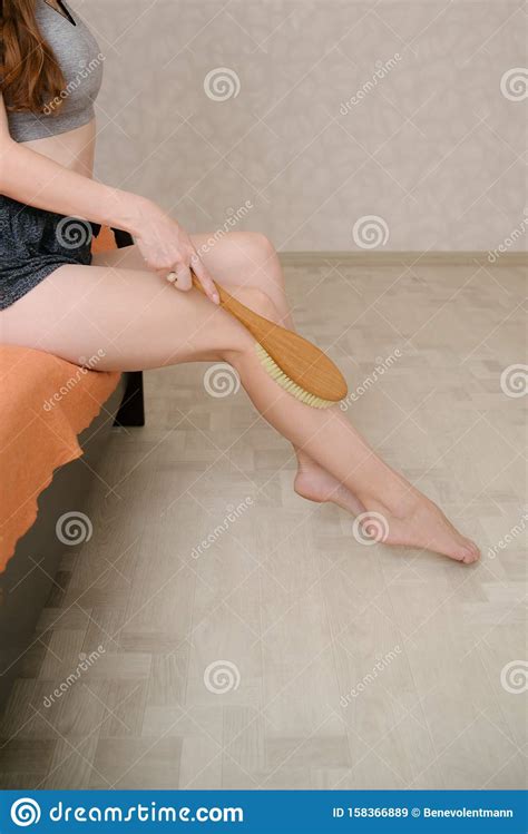 Woman Makes Massage Legs With Wooden Soft Massage Brush For Body And