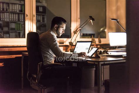 Businessman Working At Desk In Office At Night — Shining Wifi Stock