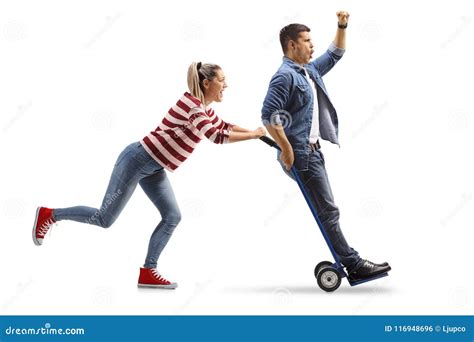 Young Woman Pushing A Hand Truck With A Young Man Riding On It Stock