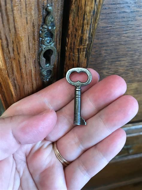 A Person Is Holding An Old Key In Their Hand