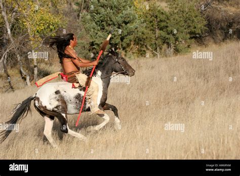 A Native American Indian Man Riding Bareback On A Horse In The Prairie