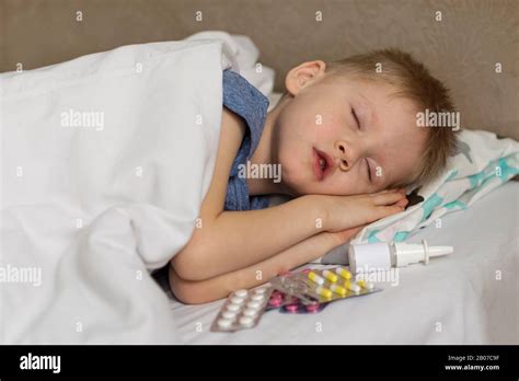 A Sick Child With A Fever And A Headache Lies In Bed The Child Sleeps