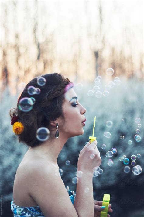 Young Woman Blowing Bubbles In Nature By Stocksy Contributor Jovana