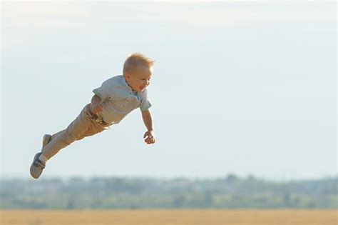 Smiling Boy Flying In The Air Playing On Field Stock Photo Download