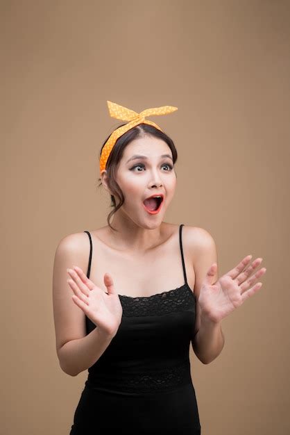 premium photo surprised asian girl with pretty smile in pinup style on yellow background