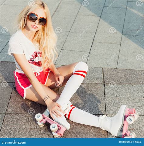 A Looker Leggy Long Haired Young Blonde Woman In A Vintage Roller Skates Sunglasses T Shirt