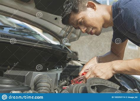A jump start is a handy way to start a car with a flat battery. Man Using Battery Jumper Cables On A Dead Battery Stock Photo - Image of using, service: 183293114
